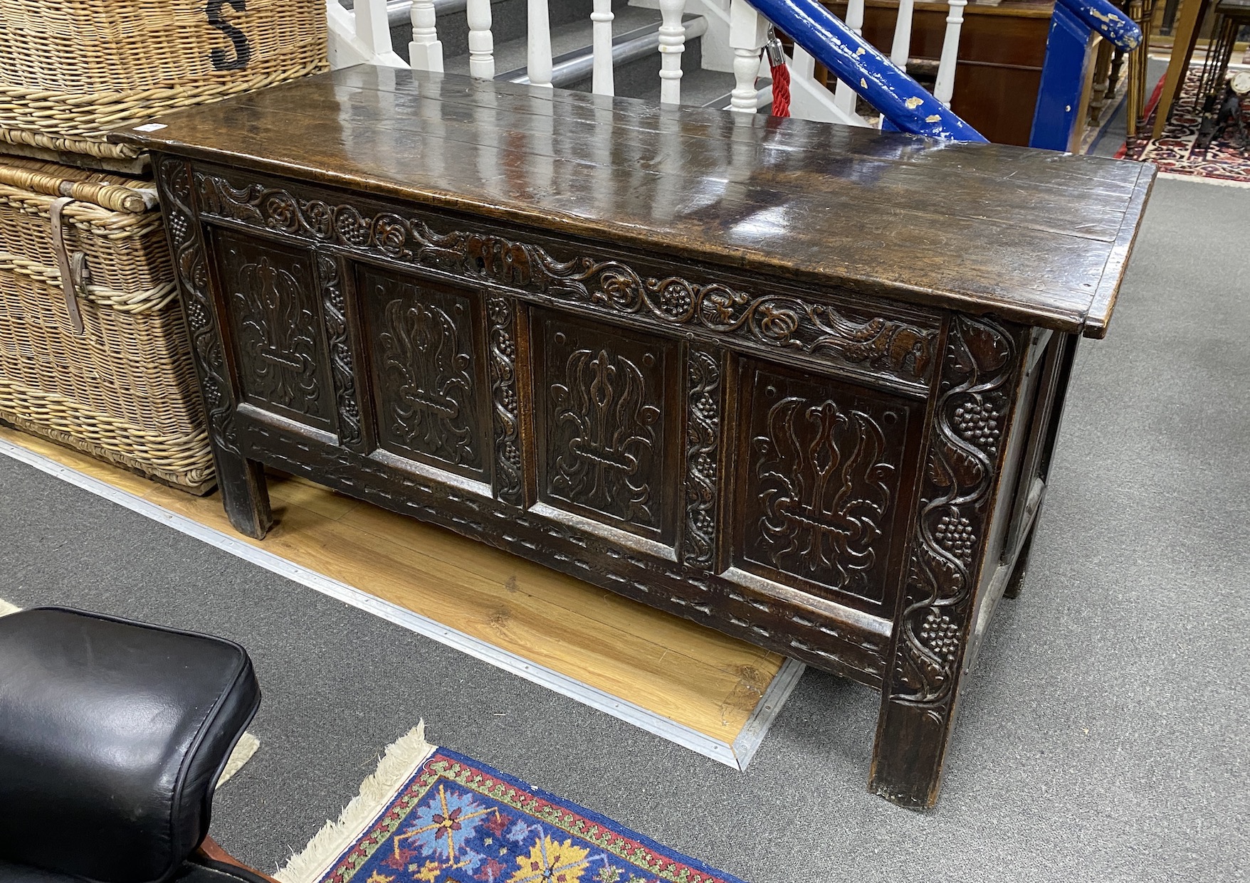 A Charles II carved oak chest, c.1680, with three plank top and four panel front, width 150cm, depth 60cm, height 76cm